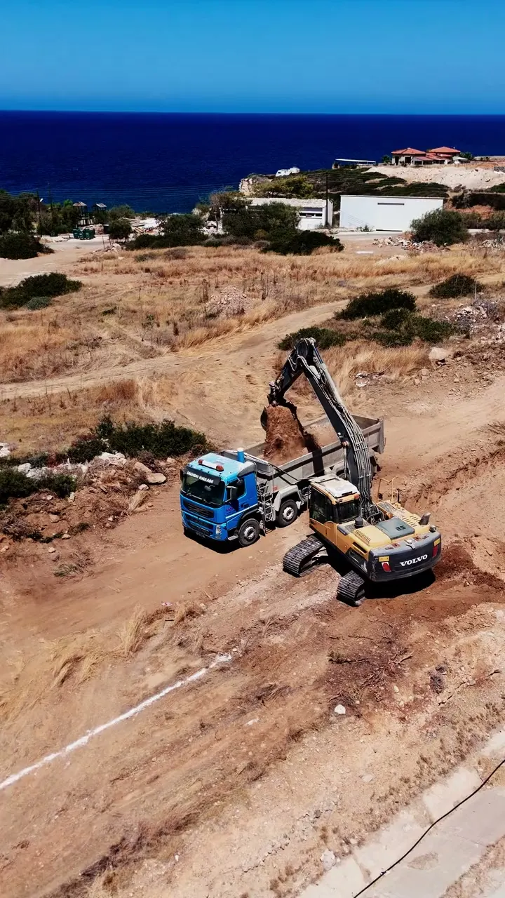 Live view: an excavator loading a truck by the sea